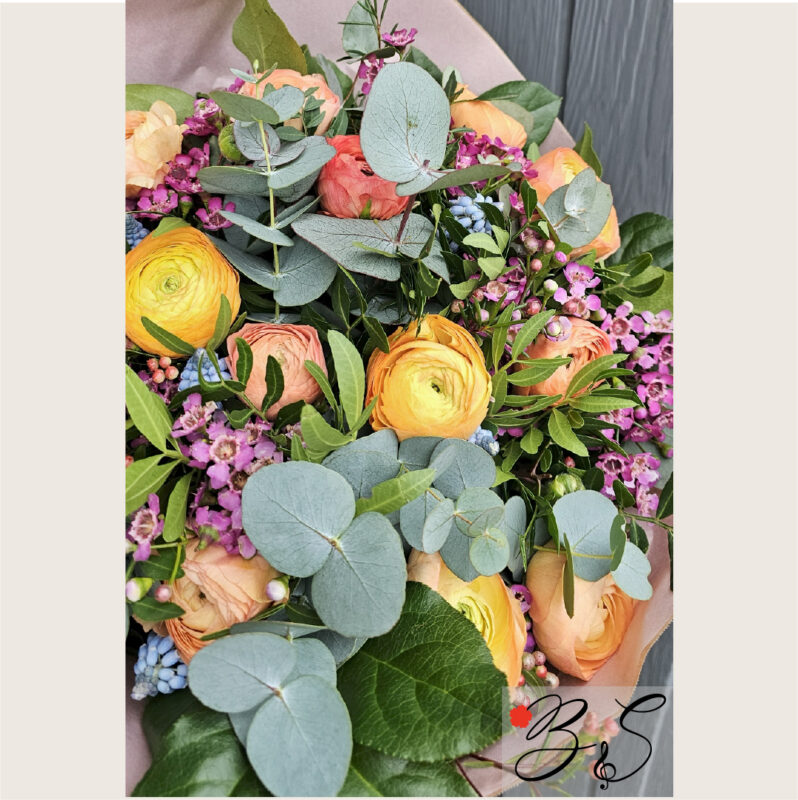 Halloween buket i orange og lilla med sort bånd og bær, pakket nænsomt og leveret planlagt og sikkert